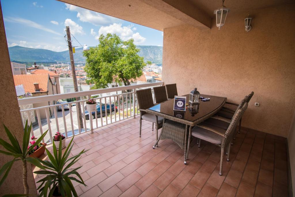 een patio met een tafel en stoelen op een balkon bij Apartments Old Town in Mostar