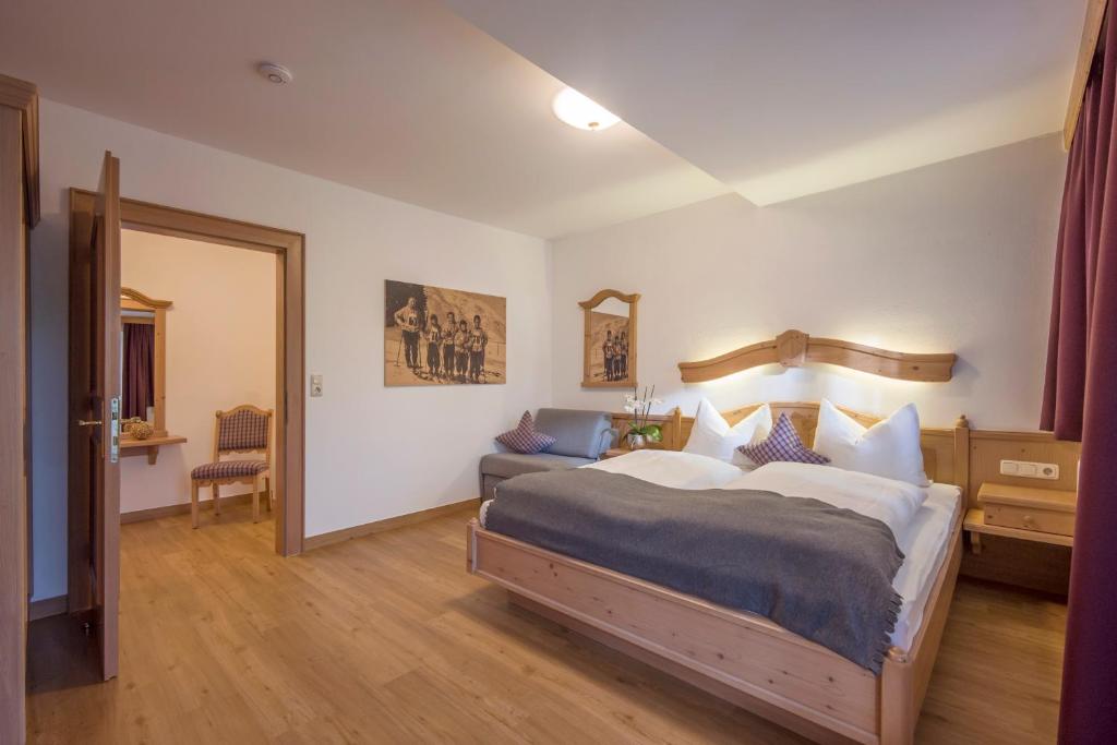 a bedroom with a large bed and a mirror at Appartements Schedererhaus in Going am Wilden Kaiser