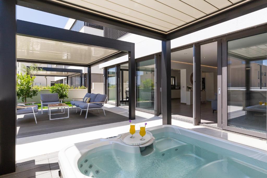 een huis met een hot tub op een patio bij Shell Luxury Residences with Pool and Whirlpool in Zadar