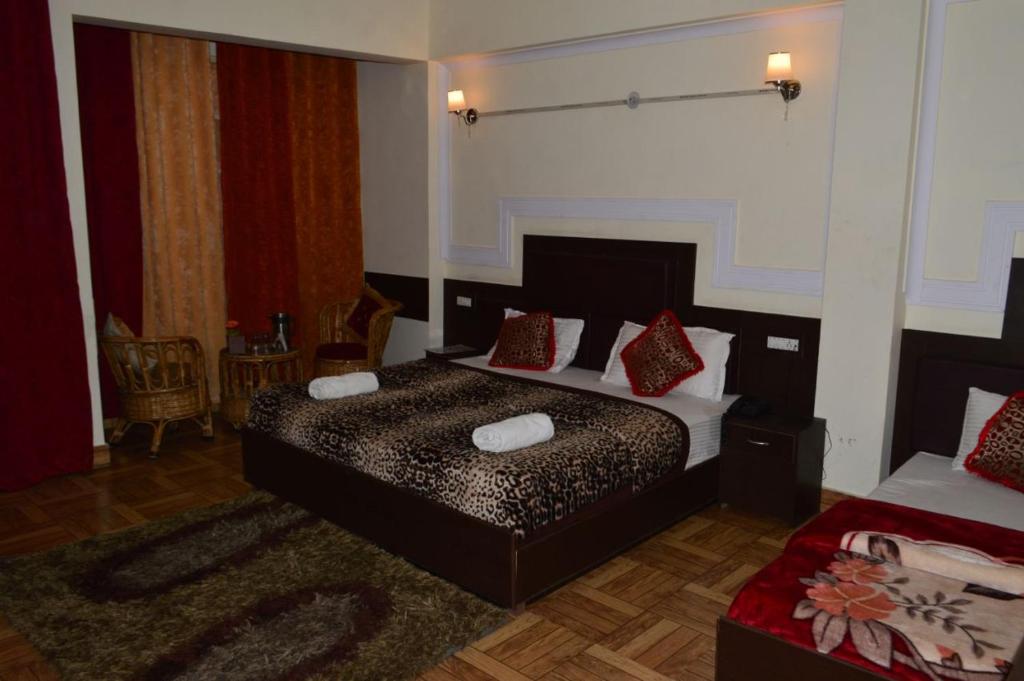 una camera da letto con un letto con cuscini rossi di Hotel Auli D a Joshīmath