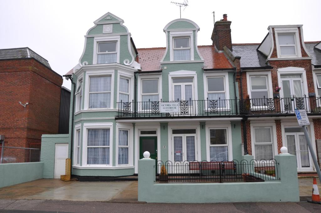 a large house with a balcony on a street at Victoria Villa Guesthouse in Clacton-on-Sea
