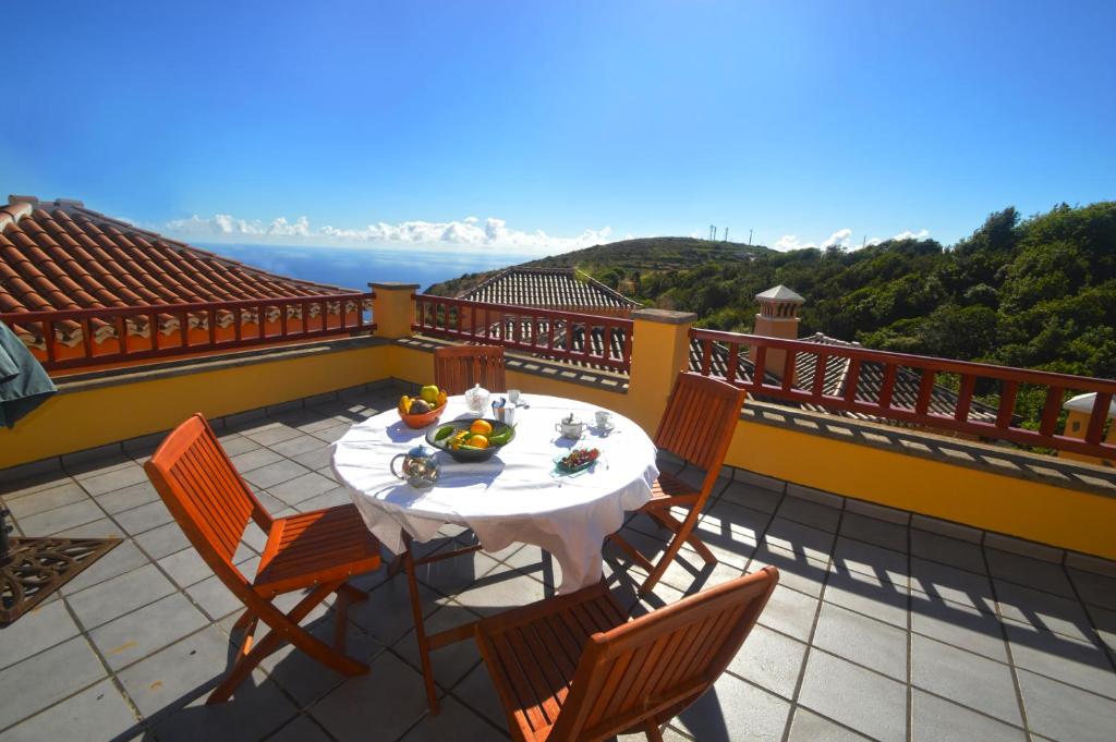 einen Tisch und Stühle auf einem Balkon mit Aussicht in der Unterkunft Emiliana in Puntallana