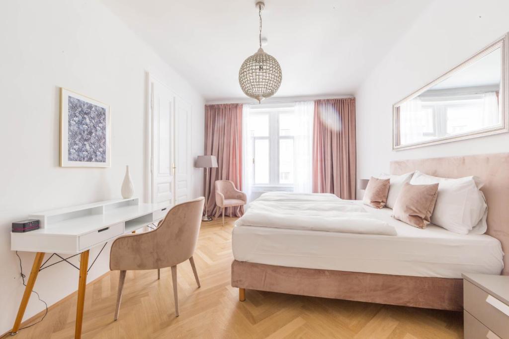 a white bedroom with a bed and a desk at City Stay Vienna – Spittelberg in Vienna