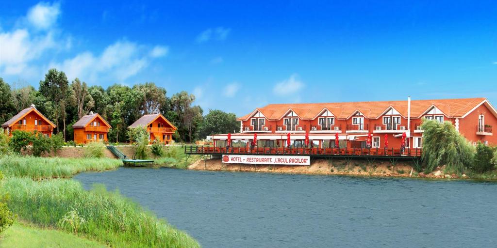 un edificio con un tren rojo junto a un río en Lacul Racilor, en Olimp