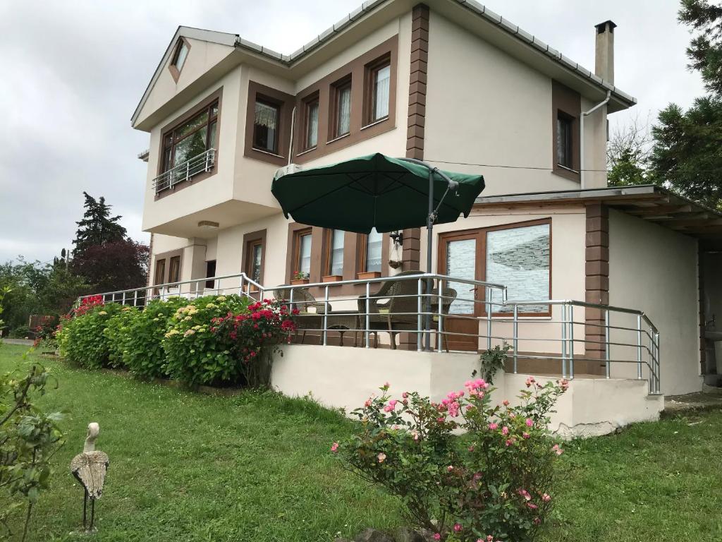 a house with an umbrella in front of it at Sea & Nature Villa Hisar in Trabzon