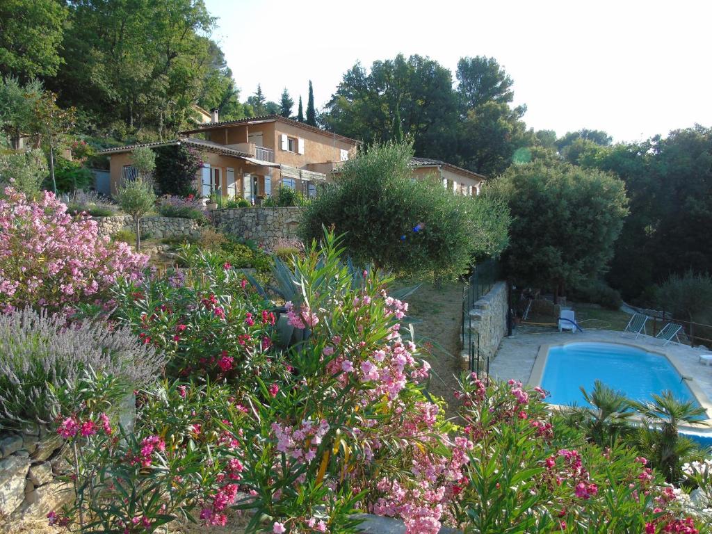 Le TignetにあるMas des Citronniersの花の咲く庭園内の家とスイミングプール