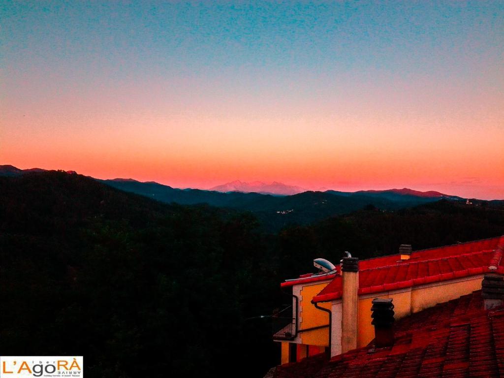 uma vista para o pôr-do-sol a partir do telhado de uma casa em L'AGOrà - Ca' du punte em Borghetto di Vara