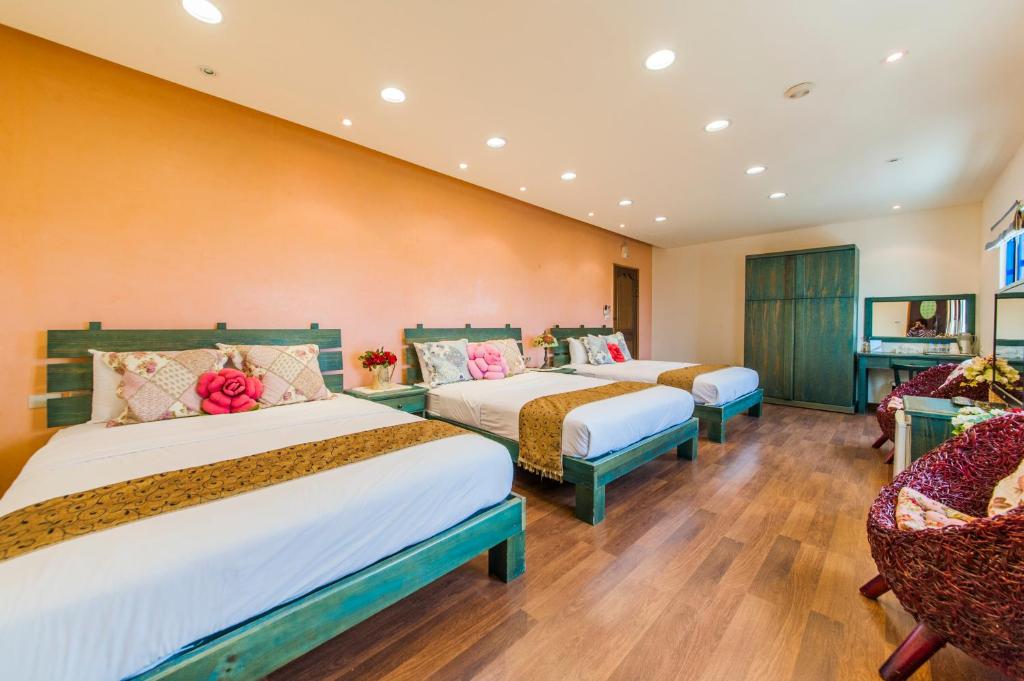 a hotel room with two beds and two chairs at Sine Ya Hostel in Hengchun South Gate
