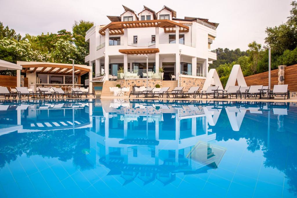 un hotel con piscina di fronte a un edificio di Poseidon Hotel a Kamínia