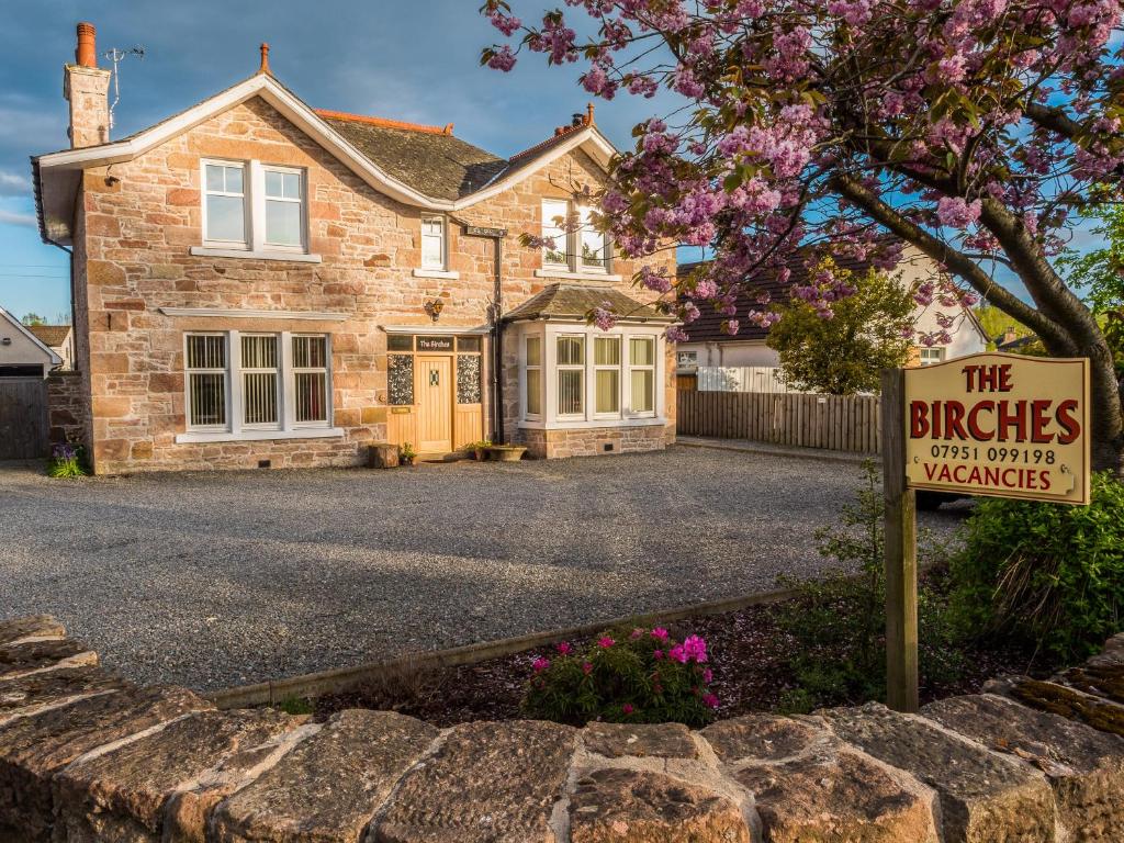 a brick house with a sign in front of it at The Birches in Dingwall