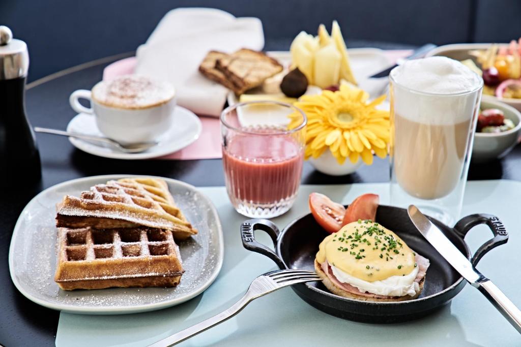 a table topped with plates of breakfast foods and drinks at SIDE, Hamburg, a Member of Design Hotels in Hamburg