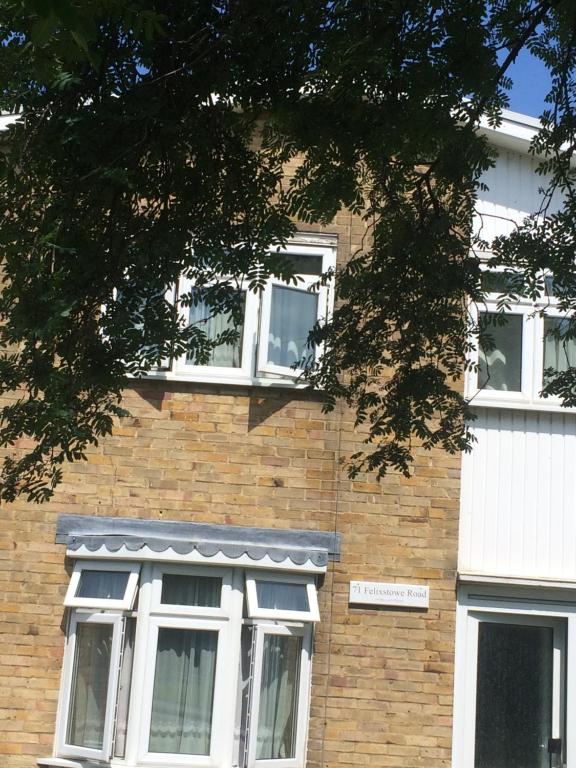 un edificio de ladrillo con ventanas blancas y un árbol en simply guesthouse, en Londres