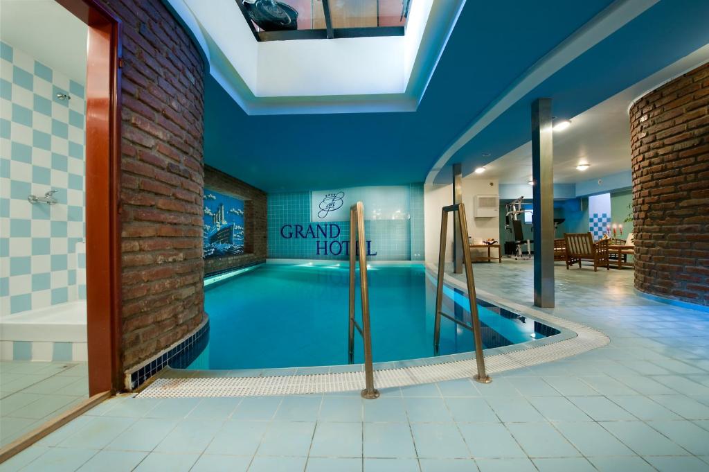 een groot zwembad in een kamer met een zwembad bij Grand Hotel in Třebíč