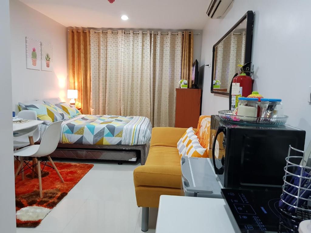 a living room with a bed and a couch and a table at Cityscape Residences Unit 510 in Bacolod