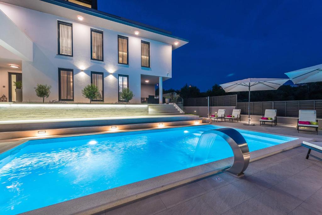 a swimming pool in front of a house at night at Villa Franica Zadar in Zadar