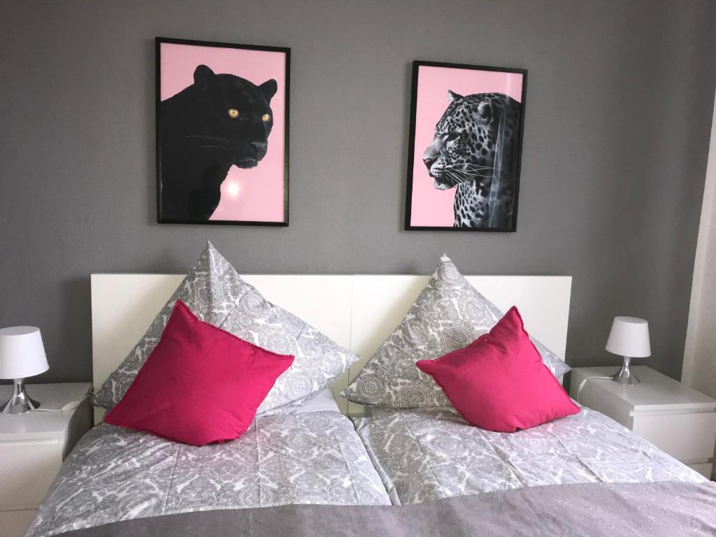sypialnia z dwoma zdjęciami tygrysów i łóżkiem w obiekcie Ferienappartements Seeliebe w mieście Bremerhaven