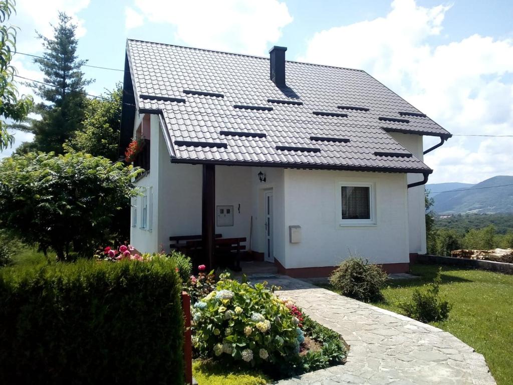 a white house with a gray roof at Apartment Nina in Drežnik Grad