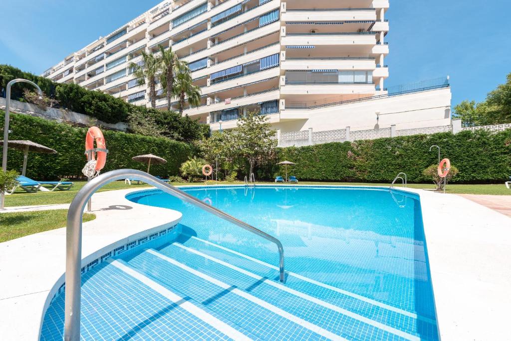 uma piscina com um edifício ao fundo em Apartamento Marbella Azul em Marbella