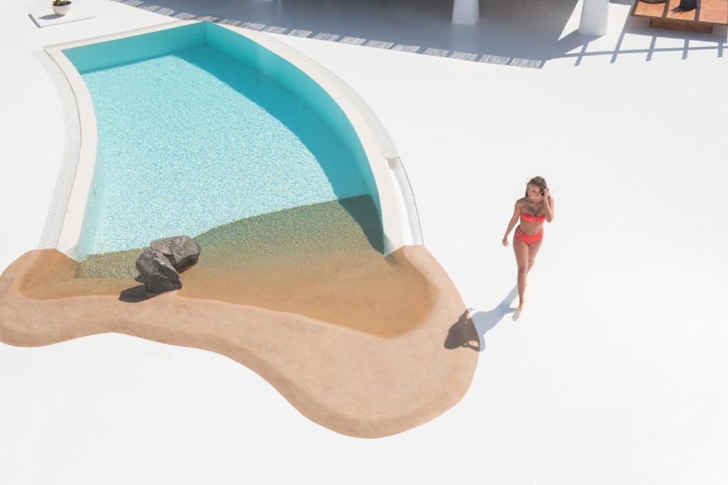an overhead view of a woman standing next to a swimming pool at Sophia Boutique Hotel in Oia