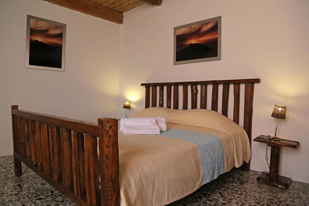 1 dormitorio con cama de madera en una habitación en B&B Casa Doria, en Castelsardo