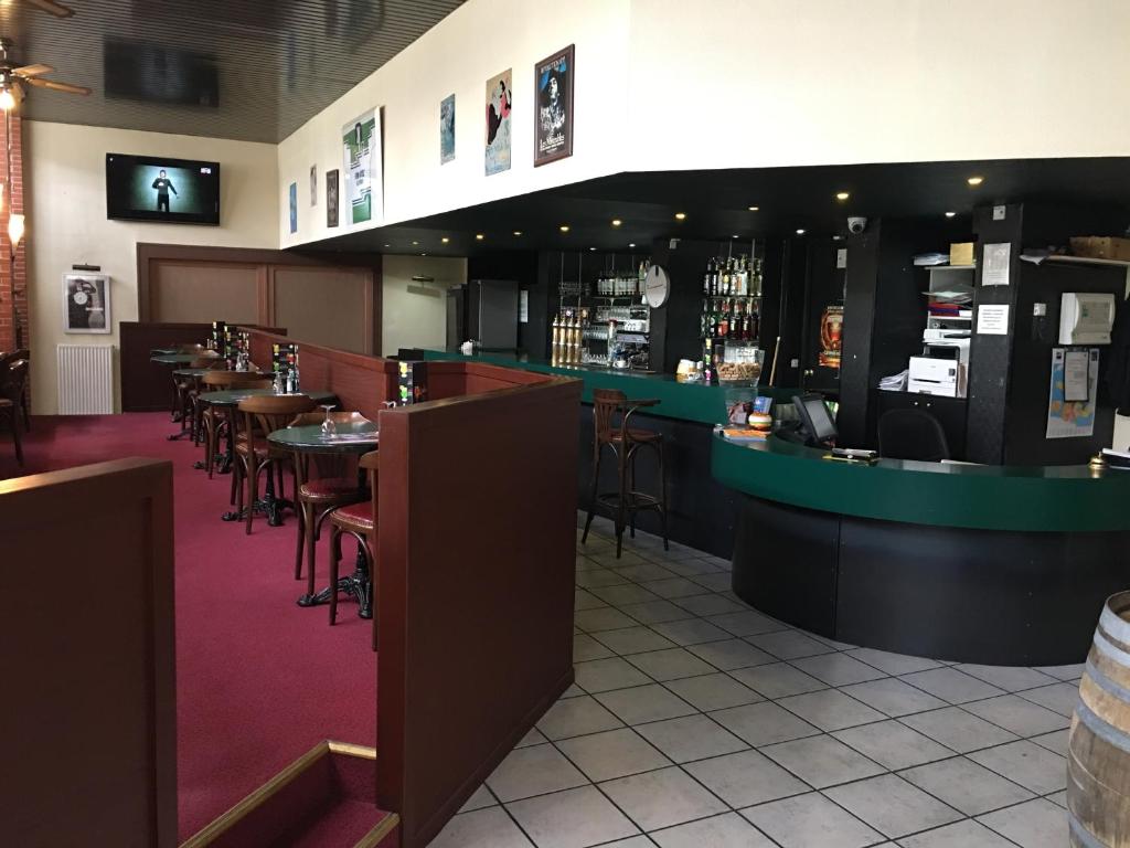 a restaurant with tables and chairs and a bar at Firmhotel le 37 in Firminy