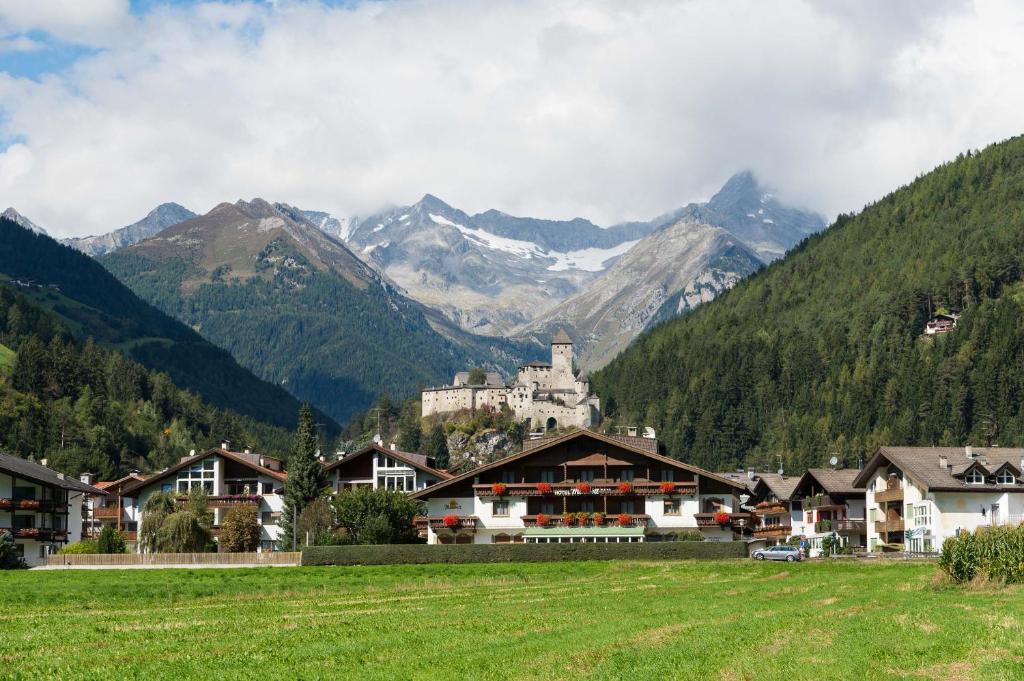 ein Dorf in den Bergen mit einem Schloss in der Unterkunft Hotel Mirabell in Sand in Taufers