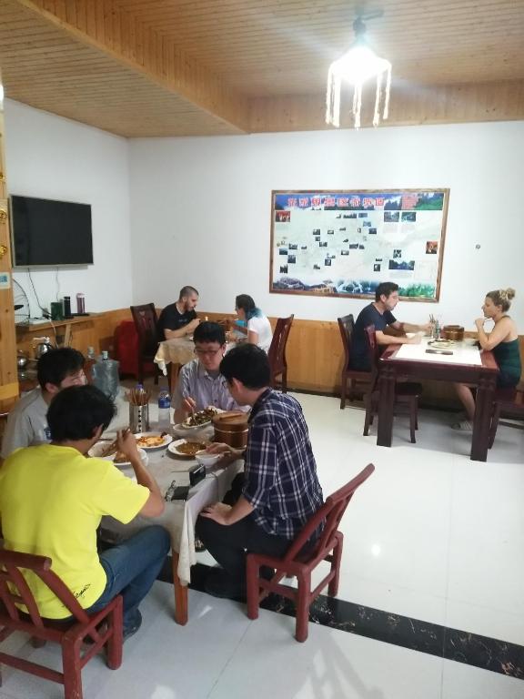a group of people sitting at tables eating food at Yangjiajie Inn in Zhangjiajie