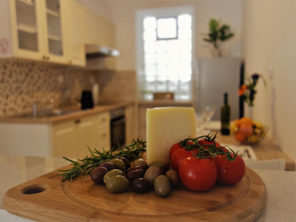 a cutting board with tomatoes and other vegetables on a kitchen counter at Apartments Vincent in Kastav