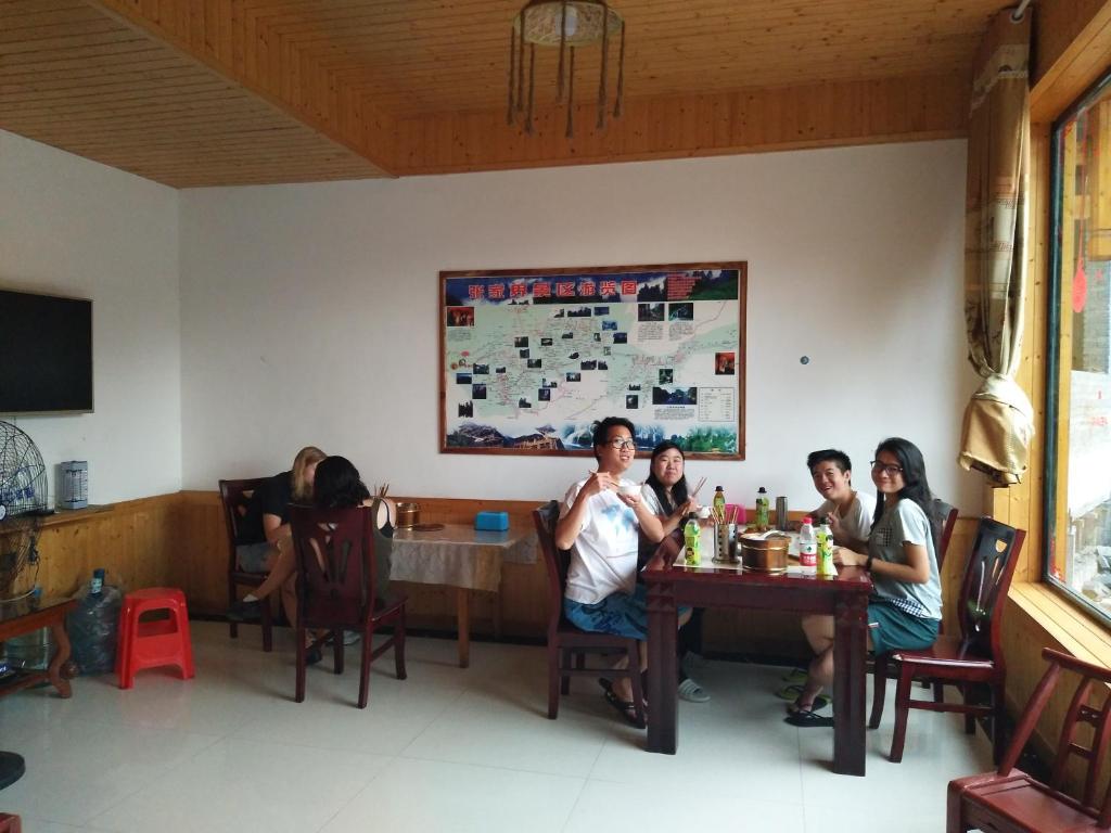 a group of people sitting at a table in a restaurant at Yangjiajie Inn in Zhangjiajie