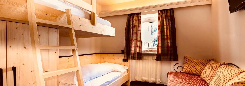 a room with two bunk beds and a window at Hotel Cir in Selva di Val Gardena