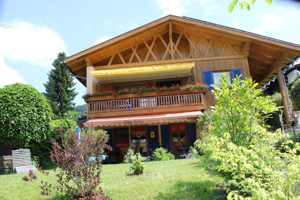 ein Haus mit einem Balkon mit Blumen darauf in der Unterkunft Ferienwohnung Schauberger in Oberammergau