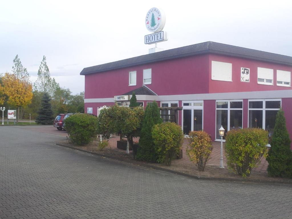 a pink building with a sign on top of it at Hotel Zur Fichtenbreite -Garni- in Coswig