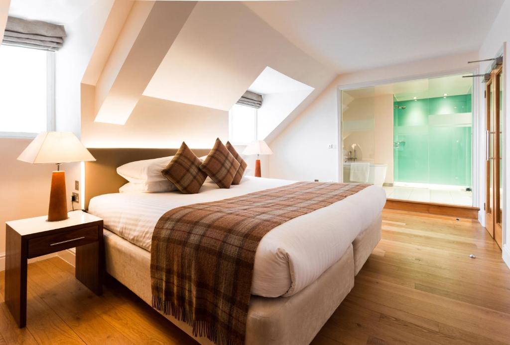 a bedroom with a large bed and a large window at ABode Canterbury in Canterbury