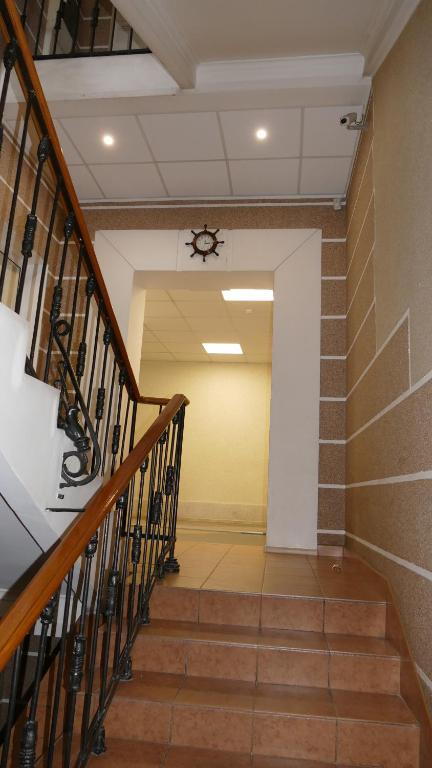 einen Flur mit Treppe mit Uhr an der Wand in der Unterkunft Hotel Admiral in Sankt Petersburg