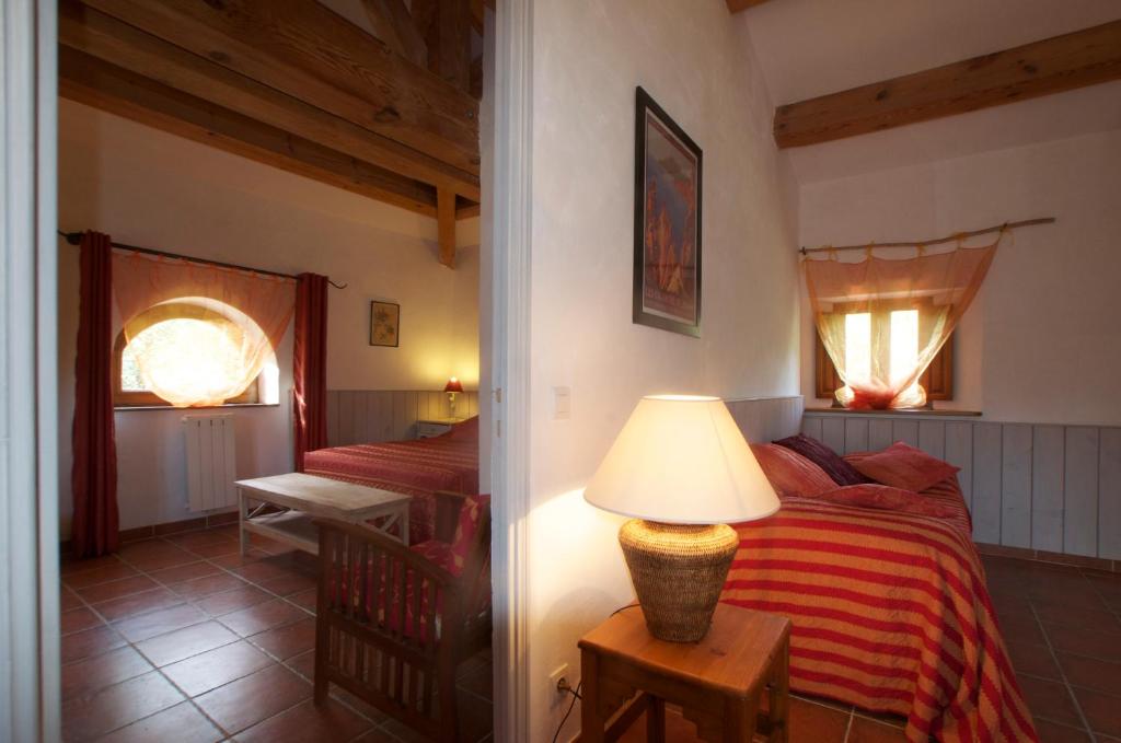 ein Schlafzimmer mit einem Bett und einer Lampe auf einem Tisch in der Unterkunft Casa-Albina-Corsica in Patrimonio