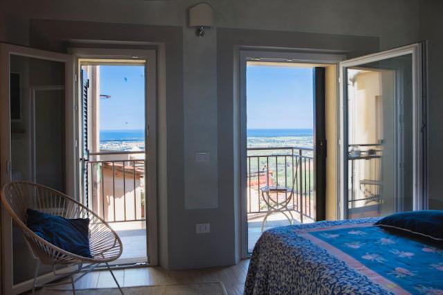 1 Schlafzimmer mit einem Bett und einem Balkon mit Meerblick in der Unterkunft NinnaNannaMare-suite apartment in Castagneto Carducci