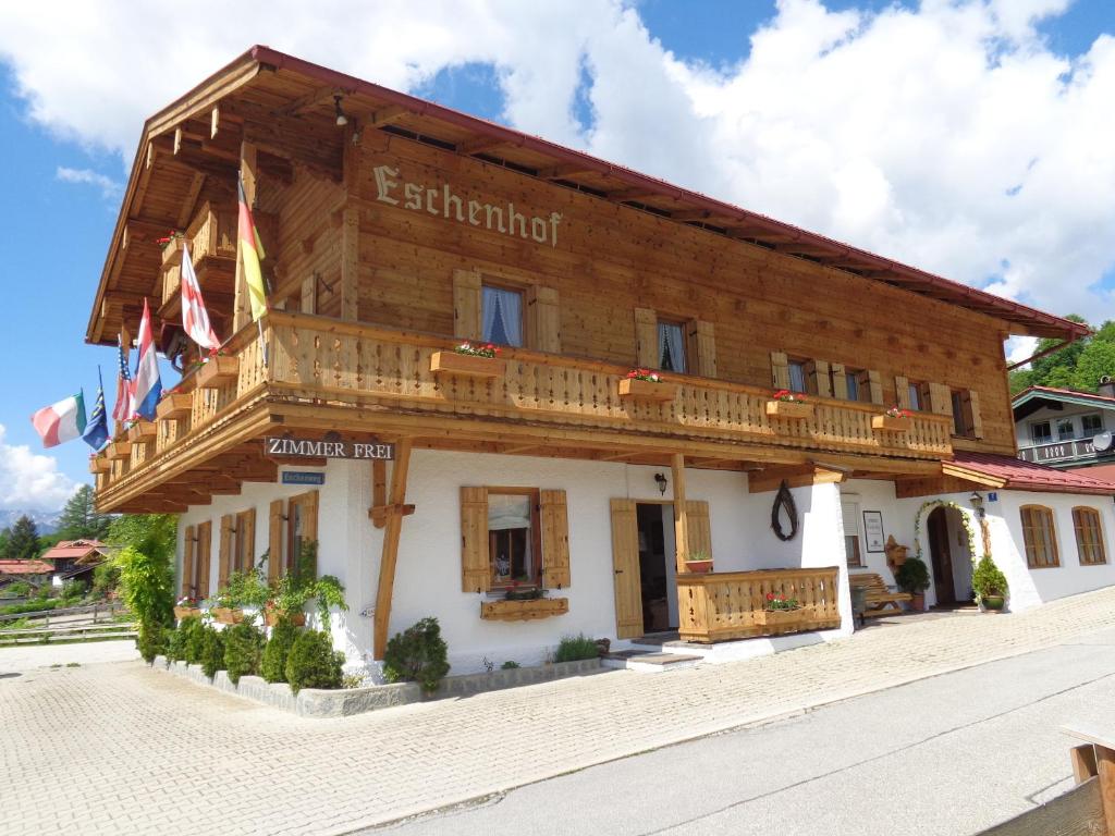 a large wooden building with a balcony at Gästehaus Eschenhof in Reit im Winkl