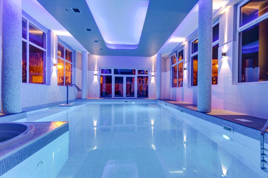 a swimming pool in a building with a swimming pool at Villa Melody in Rewal