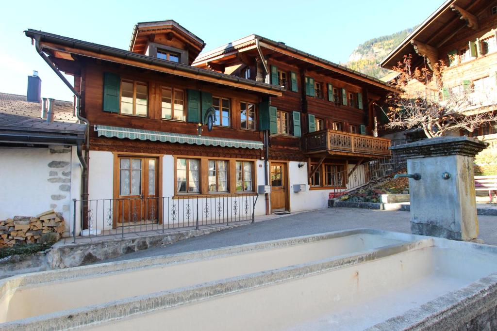 a large wooden house with a pool in front of it at Tambour 4 in Rossinière