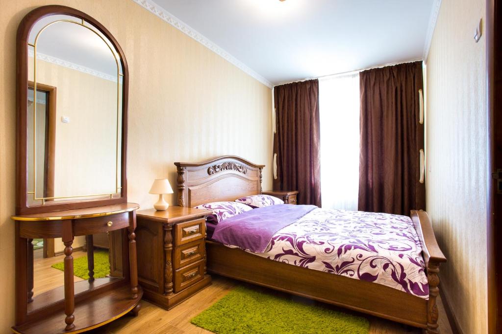ein Schlafzimmer mit einem Bett, einem Spiegel und einer Kommode in der Unterkunft Апартаменты в самом центре in Mykolajiw