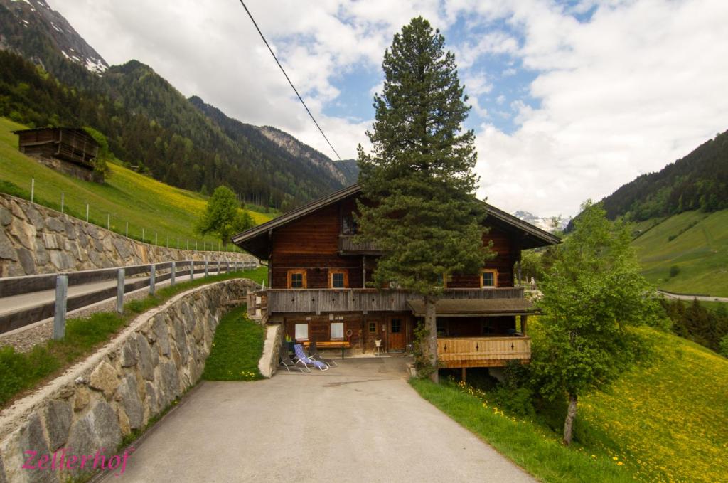 a house in the mountains next to a wall at Ferienhaus Unterbrunnhaus in Finkenberg