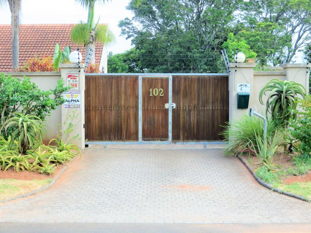 una valla de madera con una puerta en la entrada en 102 Siyayi, en Mtunzini
