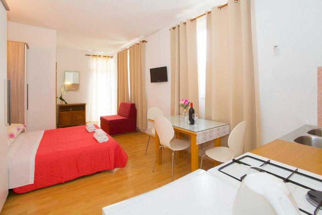 Habitación de hotel con cama, mesa y sillas en Apartments Blažević, en Makarska