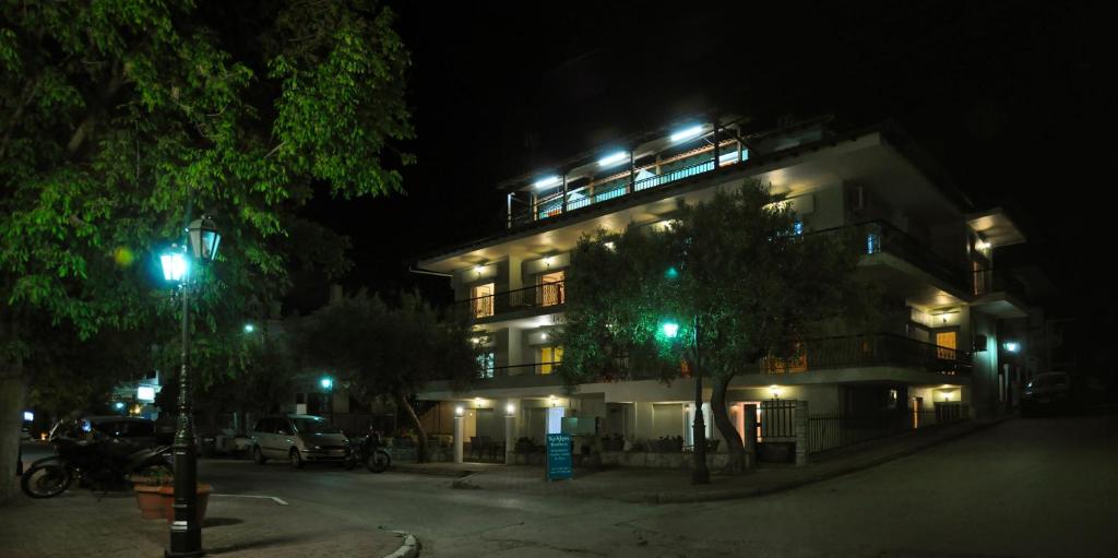 a lit up building at night with green lights at Kokkos Brothers in Kallithea Halkidikis
