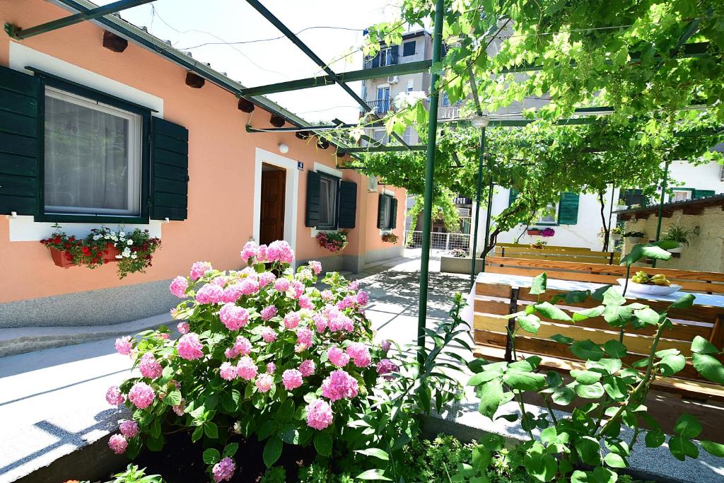 a garden with pink flowers in front of a building at Apartments Odrina in Split
