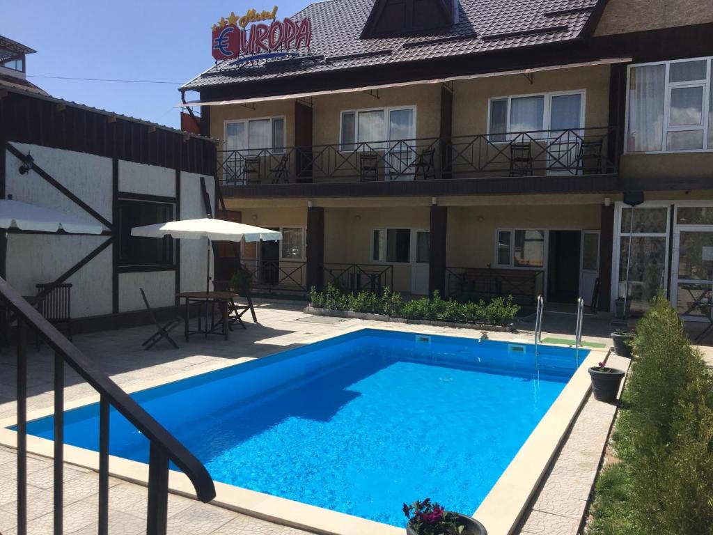 a swimming pool in front of a building at Evropa Hotel in Bosteri