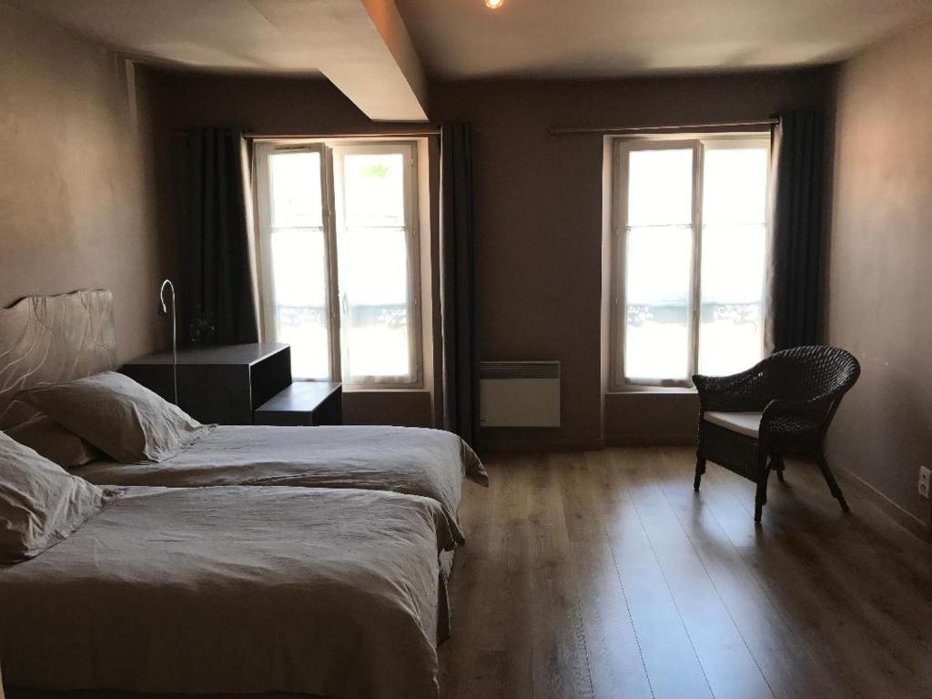 1 Schlafzimmer mit 2 Betten, einem Schreibtisch und 2 Fenstern in der Unterkunft Aux Delices de l'Abbaye in Orbais