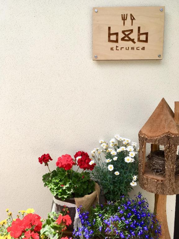 a sign on a wall with flowers on a table at Etrusca Polsa in Brentonico