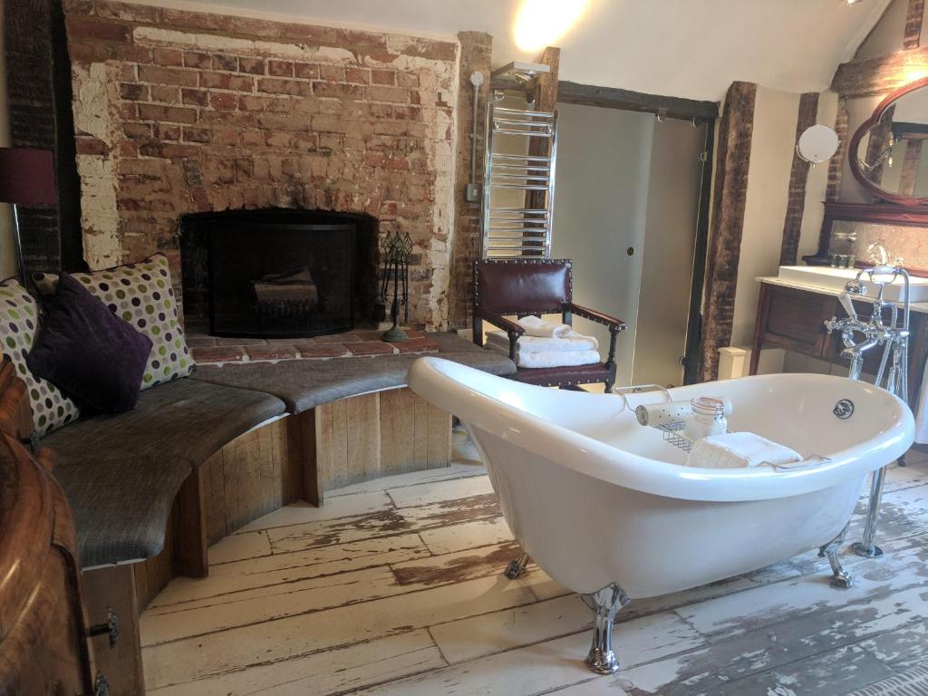 a bath room with a tub and a chair in it at The Wellington in Welwyn