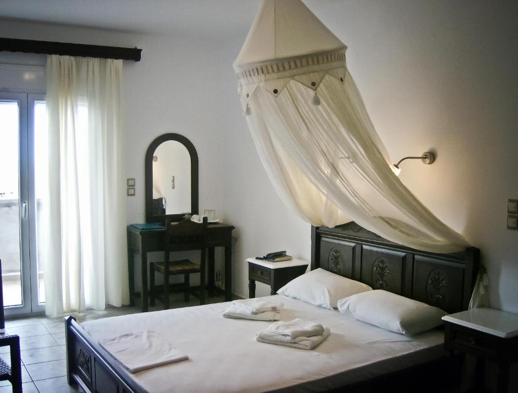 ein Schlafzimmer mit einem Bett mit zwei Handtüchern darauf in der Unterkunft Evgatis Hotel in Kondiás